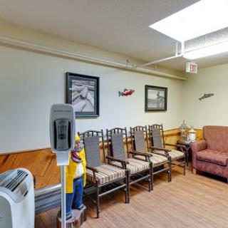 A waiting area in a hospital featuring several chairs, a couch, and artwork on the walls.