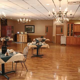 A spacious dining area featuring elegant tables, tasteful decor, and decorative chandeliers.