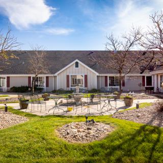 A charming residential house with a well-maintained yard and clear blue sky.