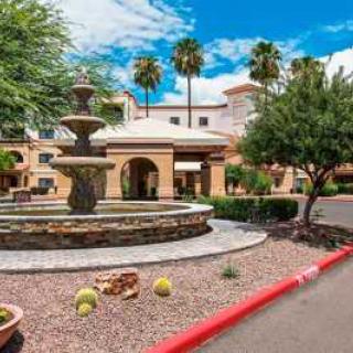 A scenic hotel entrance with a fountain and desert landscaping.
