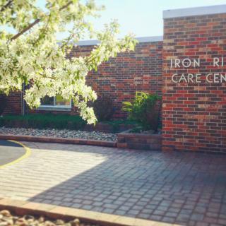 Entrance to a care center with brick facade and spring landscaping.