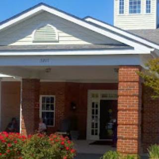 A welcoming building with a distinctive architectural design, featuring a front entrance and vibrant landscaping.
