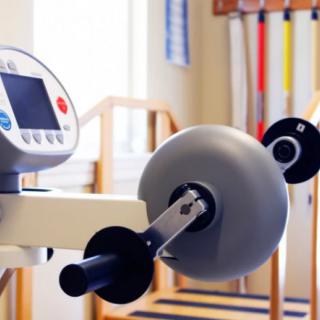 Exercise equipment in a physical therapy setting, featuring a machine with adjustable settings.