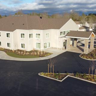 Aerial view of a modern residential building with landscaped surroundings.