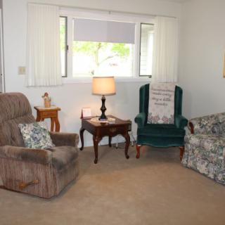 A cozy living room with comfortable seating and a warm lamp.