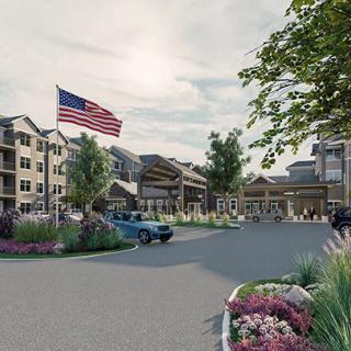 A residential complex with landscaped surroundings, featuring apartment buildings and an American flag.