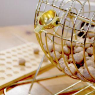 A bingo cage with numbered balls used for drawing random selections in a game.