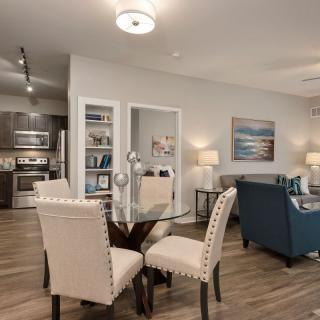 A modern open floor plan living space with a dining area and kitchen.