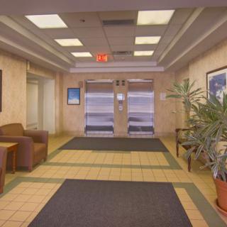 A clean and bright lobby area with seating and elevators.