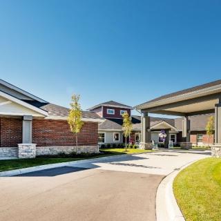 A modern facility with a driveway entrance and landscaped surroundings.