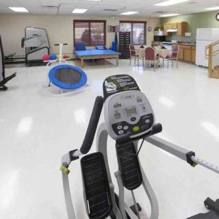 A well-equipped indoor gym featuring an elliptical machine and other fitness equipment.