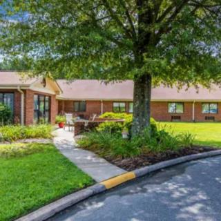 A charming brick house with a well-maintained garden and spacious lawn.
