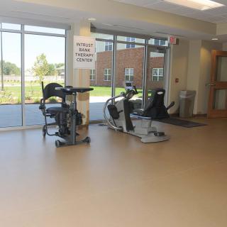 A well-lit fitness center with stationary bikes near large windows.
