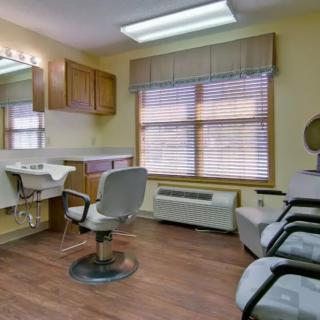 Interior of a modern hair salon with styling chairs and large windows.
