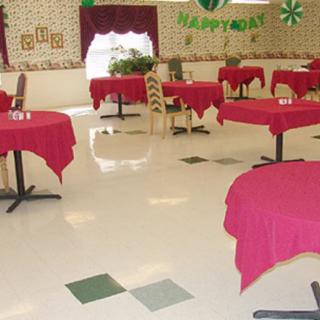 An empty restaurant interior with red tablecloths and festive decorations.