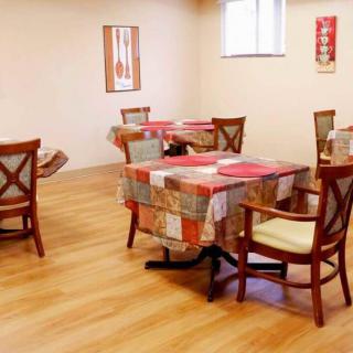 A cozy dining area with neatly arranged tables and chairs on wood flooring.