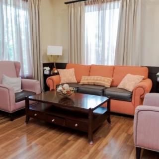Cozy living room with a peach sofa and matching armchairs, centered around a wooden coffee table.