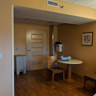 A cozy room featuring a table and chairs, with warm-toned walls and decorative art.