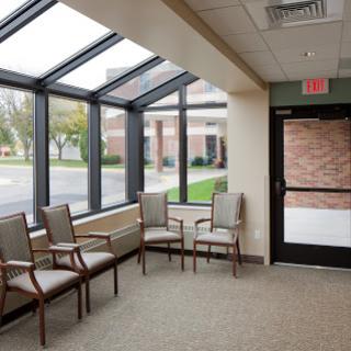 A bright and inviting waiting area featuring comfortable chairs and large glass windows.