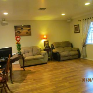 A cozy living room with sofas, a television, and warm lighting.