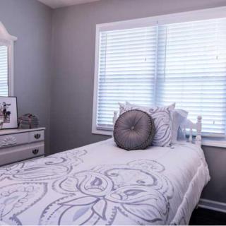 A minimalist bedroom with a single bed and modern decor in gray tones.