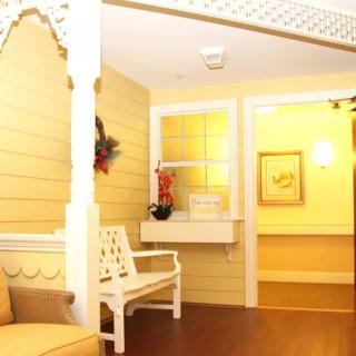 A warmly lit lobby area with wooden paneling, featuring a white bench and decorative elements.