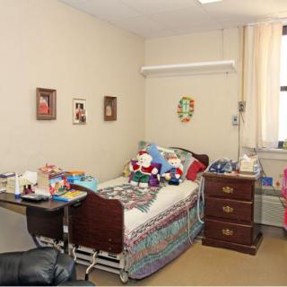 A hospital room with a bed surrounded by toys and decorations.