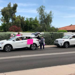A community gathering with decorated cars and cheerful participants.