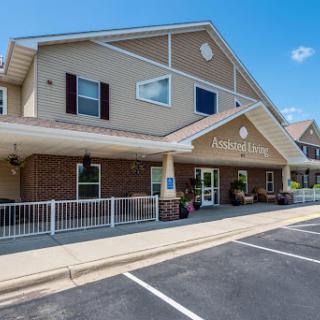 A welcoming residential building with an inviting front entrance and clear blue skies overhead.