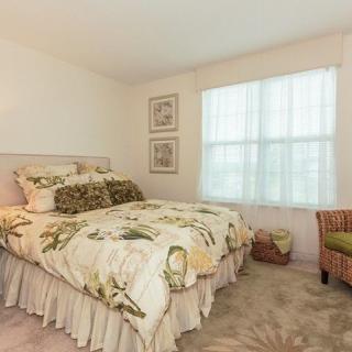A cozy bedroom with floral bedding and a window letting in natural light.