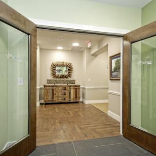 A welcoming entrance featuring elegant wooden doors leading into a tastefully decorated reception area.