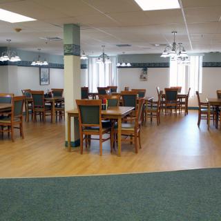An empty dining room with neatly arranged tables and chairs.
