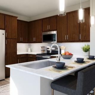 A modern kitchen with wooden cabinets, an island, and contemporary lighting.
