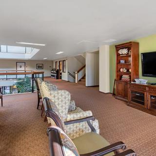 A spacious living room with a seating area, television, and bookshelf.