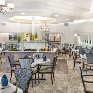A spacious and elegantly decorated dining area with neatly arranged tables and chairs.