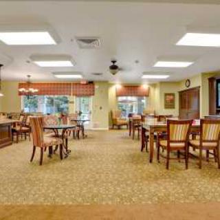 A well-lit dining area with multiple tables and chairs arranged neatly.