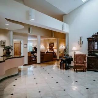 A spacious lobby area with elegant furniture and a marble floor.