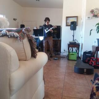A musician performing in a cozy living room setting.