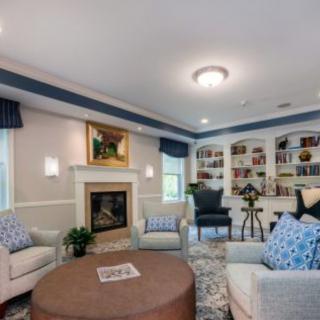 A cozy living room featuring a fireplace and built-in bookshelves, with comfortable armchairs and tasteful decor.