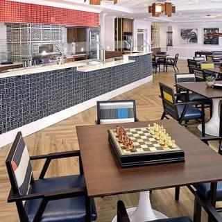 A modern cafe with a chess board on a table and stylish seating.