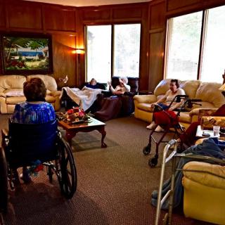 Elderly residents relaxing in a cozy living room setting at a nursing home.