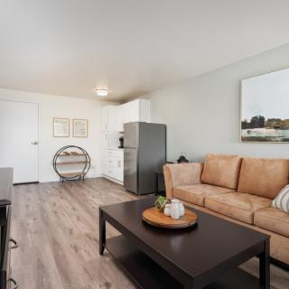A modern living room with a tan sofa, wooden coffee table, and minimalist decor.