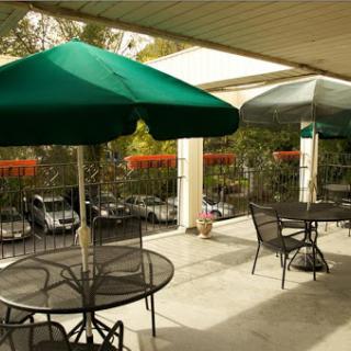 A cozy outdoor patio area with green umbrellas and tables, perfect for dining al fresco.