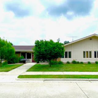 A beautiful view of two distinct houses with lush green grass and a welcoming sidewalk.