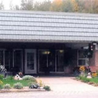 A house with a prominent entrance, surrounded by a landscaped garden.