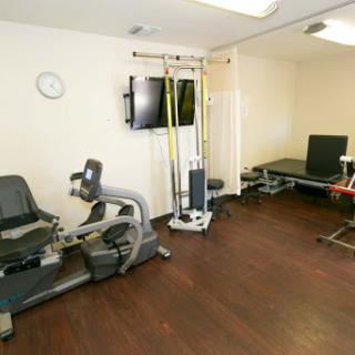 A well-equipped fitness and rehabilitation room featuring various exercise equipment.