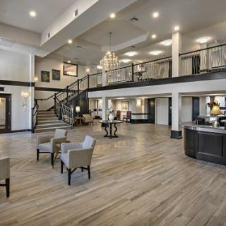 A spacious and modern hotel lobby with a grand staircase and elegant furnishings.