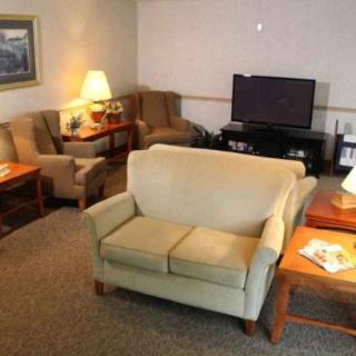 A cozy living room with a sofa, armchairs, and a TV.