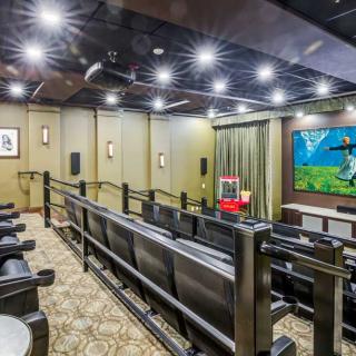 A luxurious home theater with tiered seating and a large projector screen.