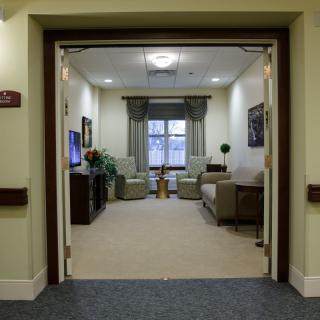 A cozy lounge area with comfortable seating and a large window.